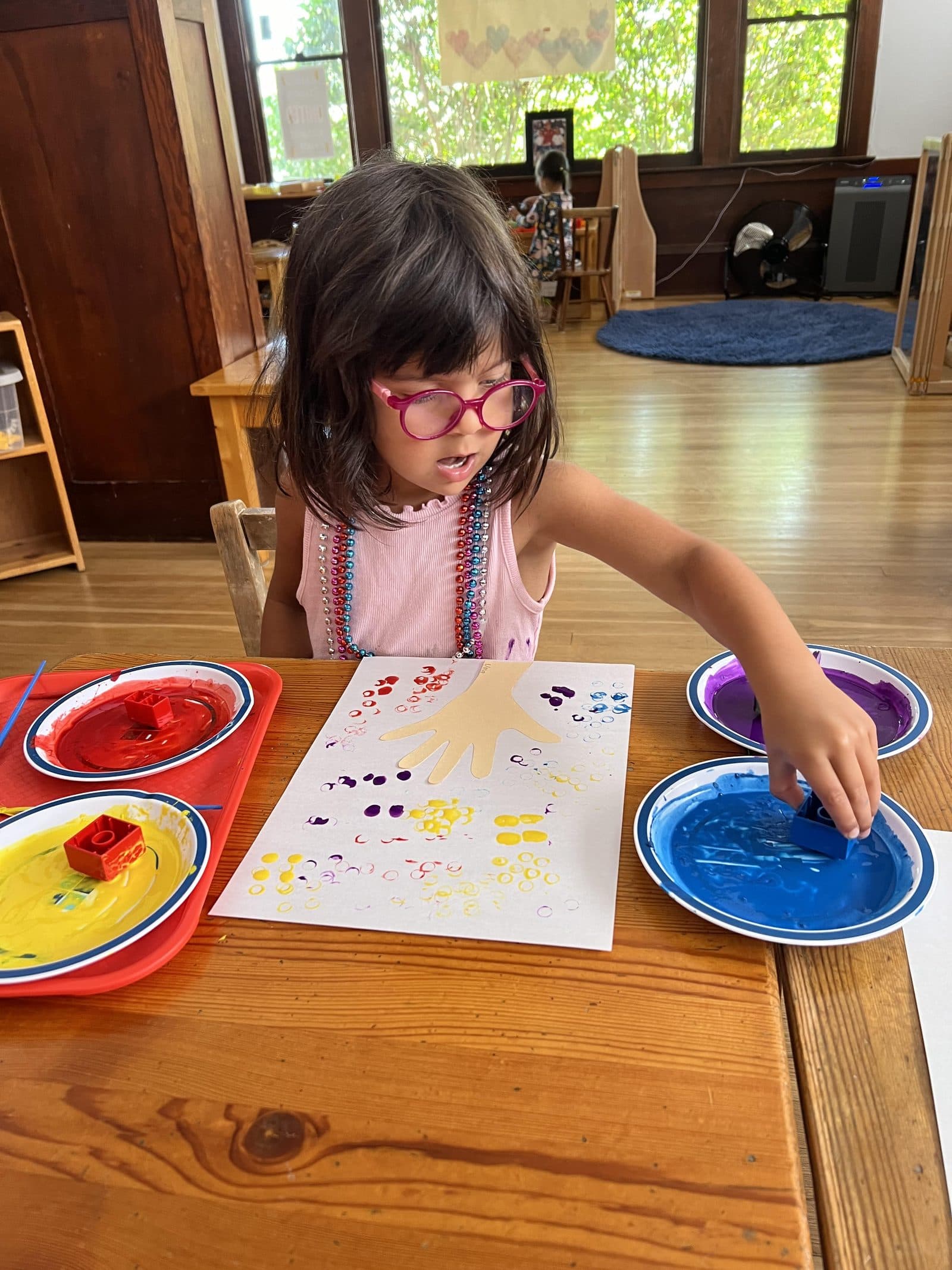 A young student deep in concentration during dot-painting work